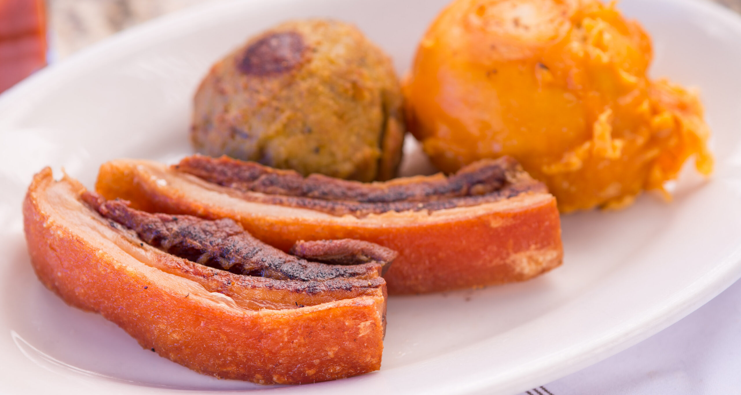 Chicharrón con papa rellena y pionono at La Lechonera Restaurant